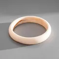 Macro view of minimalist cream acrylic bracelet featuring elegant marble ink-dye textures - Beige