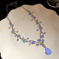 Detailed shot of blue resin flower necklace with a large teardrop pendant on a plate - Necklace (HN11814) / Silver, Blue