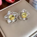 Close-up of elegant flower stud earrings with transparent resin petals and yellow crystal - Silver Needle / Transparent Yellow