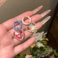 Detail shot of colorful asymmetrical heart earrings with resin flower and heart patterns. - Ear Buckle-Colorful