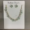 Detailansicht des sprühlackierten Blumenhalsketten- und passenden Ohrstecker-Sets - Halsketten- und Ohrring-Set / Grün/Weiß