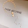 Elegant layered gold-tone necklace featuring white pearls with shell and flower charms - 4-Layer Necklace Style / Gold