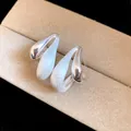Dettaglio orecchini a goccia con texture in argento spazzolato e finitura lucida. - Argento