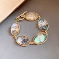 Detail view of a vintage gold OT bracelet with iridescent faceted oval resin stones - Gold-Blue