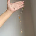 Gold beaded necklace featuring colorful natural stone accents and a delicate starfish charm. - Gold