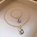 Detail view of vintage gold curb chain necklace and bracelet set with pearl and grey stone. - Necklace and Bracelet Set / Gold