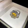Macro view showing a square yellow zircon ring detail inside an elegant jewelry box - Silver-Yellow