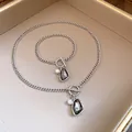 Detailed view of vintage silver chain jewelry set with grey crystal and pearl pendants. - Necklace and Bracelet Set / Silver