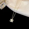 Detail der 18 Karat vergoldeten Halskette mit Katzenaugenstein-Blume und Zirkonia - Doppel-C-Blumen-Stil (Gold)