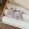 Close-up view of handmade purple beaded mermaid tail stud earrings in a jewelry box. - Fish Tail Style (HE31327) / Purple