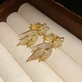 Detail of 14k gold plated clip-on earrings with sparkling zirconia floral leaf design - Clip-On Earrings / Gold