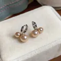 Detailansicht eleganter champagnerfarbener Perlenohrringe in Kirschform auf Samtetui - Ohrbuckle / Hellkaffeegold