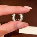 Detailed macro view of silver C-shaped earrings showing intricate lace edges and white pearls - Tops / Silver