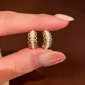 Macro view showing delicate gold lace details on C-shaped pearl earrings with CZ - Tops / Gold