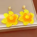 Macro detail of vibrant yellow and orange resin flower earrings on a luxury display box - Flower Style (HE34018) / Gold and Yellow