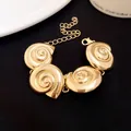 Detail view of vintage gold shell bracelet with spiral charms on black background. - Bracelet / Gold