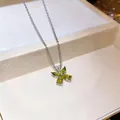 Close-up of olive green zircon flower pendant on a dainty silver-tone chain necklace - Silver-Green