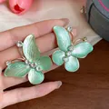 Close-up of butterfly earrings with mint enamel and sparkling zircon details. - Butterfly Style (Alloy) / Silver Needle / Gold/Green