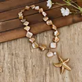 Close-up detail of an irregular shell bead necklace with a large golden starfish pendant. - Gold and Coffee