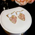 Primer plano de pendientes de corazón con lazo blanco, cristales rosas y perlas finas - Pendientes de Botón con Colgante de Corazón y Lazo / Aguja de Plata - Oro Blanco Rosa