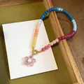 Close-up detail of a colorful dopamine glass beaded necklace with pink flower pendant - Necklace-Red