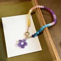 Detailed view of a colorful dopamine glass beaded necklace with a purple flower pendant. - Multicolor Purple Necklace