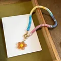 Vibrant dopamine style glass beaded necklace featuring a clear amber flower pendant - Transparent Orange Multicolor Necklace