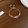 Close-up of sparkling silver bracelet with pink zircon bow and adjustable chain - Bracelet (Silver-Pink)