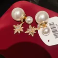 Macro di elegante ciondolo a stella in zircone e perle bianche su velluto rosso - Oro+Bianco