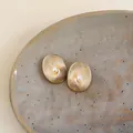 Dettaglio di orecchini ovali placcati in oro 18 carati con perla centrale e trama a spirale. - Placcato Oro 18K Ovale / Oro