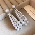 Dettaglio ravvicinato di orecchini vintage con perle e ago d'argento in un portagioie - Argento