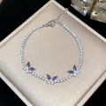 Detailed macro shot of silver butterfly bracelet with purple zircons on jewelry box. - Silver-Purple