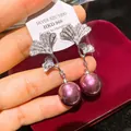 Dettaglio orecchini ginkgo con zirconi e perle viola pendenti su perni in argento - Argento + Porpora
