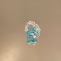 Detailaufnahme der Textur eines modischen Perlenrings mit blauer Blume aus Harz - Blau