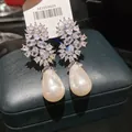 Primo piano di orecchini pendenti di lusso con zirconi scintillanti e perle a forma di pera - Argento