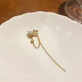 Detailed macro view of a golden butterfly tassel ear cuff with crystal accents. - Single Piece (Real Gold Plated) / Gold