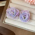 Close-up of handmade purple and blue beaded flower earrings in a jewelry box - Purple