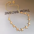 Elegante Halskette mit goldenem Seestern-Anhänger und glänzendem Metall-Finish auf der Textur. - Gold