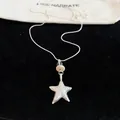 Close-up of silver star pendant necklace with "Promise me" engraving on black velvet. - Star Pendant / Silver