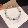 Elegant silver bracelet with colorful oval zircons and crystal flowers on a cream pouch - Style 6 Bracelet