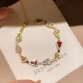 Luxurious colorful zircon heart link bracelet in gold finish resting on a beige gift pouch - Style 9 Bracelet