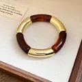 Detailed macro view of acrylic and gold segmented bracelet with tortoiseshell pattern - Eco-Friendly Gold-Coffee Brown