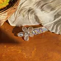 Macro view of an elegant acrylic flower hair clip featuring pearls and purple crystals - Rhinestone Flower (HH9880) / White
