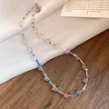 Close-up detail of a colorful bohemian crystal beaded necklace on a wooden background - White with Multicolored Stones
