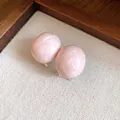 Detailed view of pink oval marble texture earrings on a minimalist linen background - Oval Textured Style / Pink