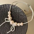 Elegant handcrafted white pearl beaded necklace featuring a stylish bow design for women - White