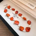Primo piano di una collana con perline arancioni e stelle marine bianche in stile resort - Collana Arancione