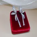 Detail view of sparkling butterfly earrings with pearls and zircons on red velvet - Silver