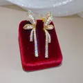 Close-up of luxury 18k gold plated butterfly clip-on earrings with zircons and pearls. - Gold