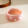 Detailed macro shot of a chunky pink resin bangle with white star pattern decorations - Five-pointed Star Pattern / Light Pink